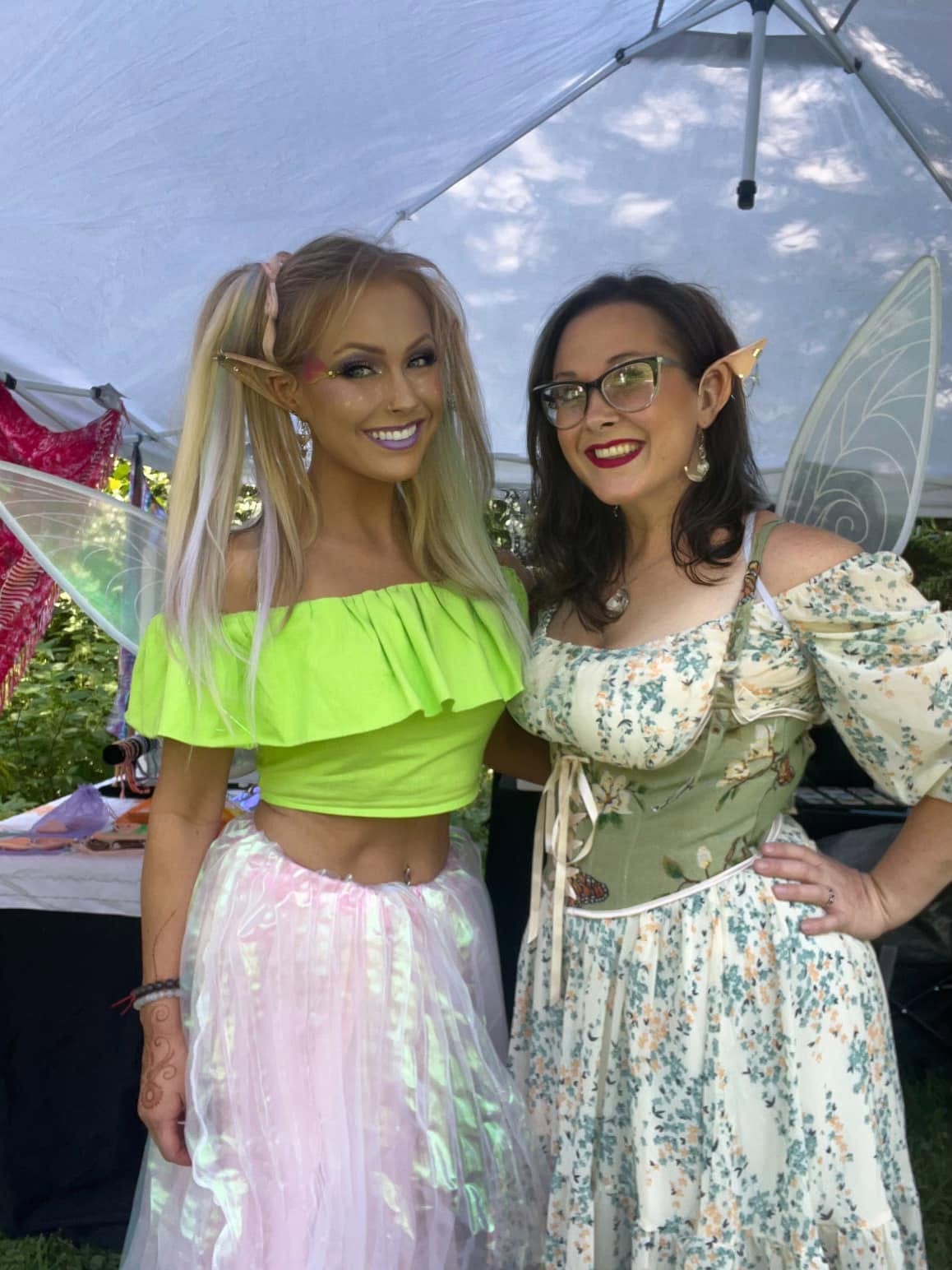 Two fairy performers with wings and elf ears at an outdoor event