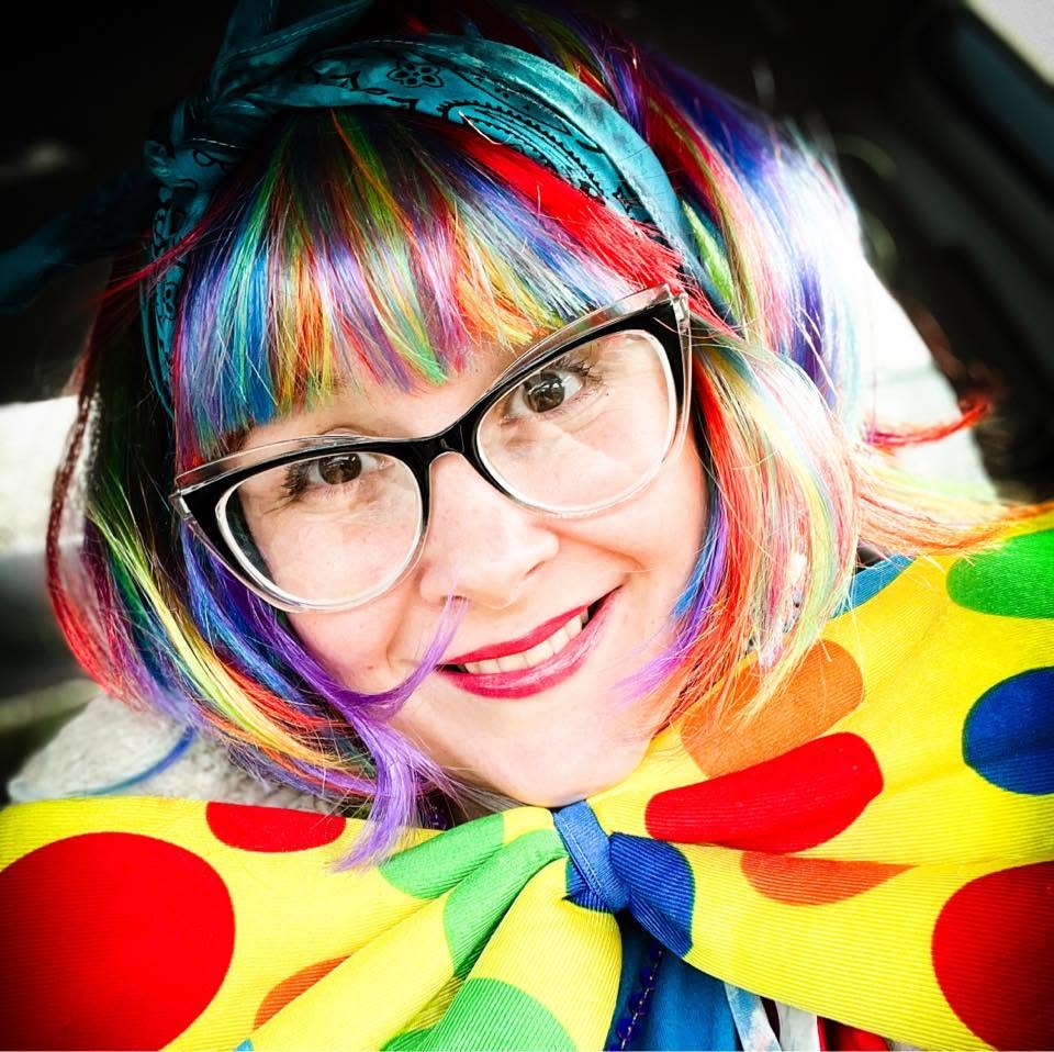 Rainbow-haired clown character with polka-dot bow
