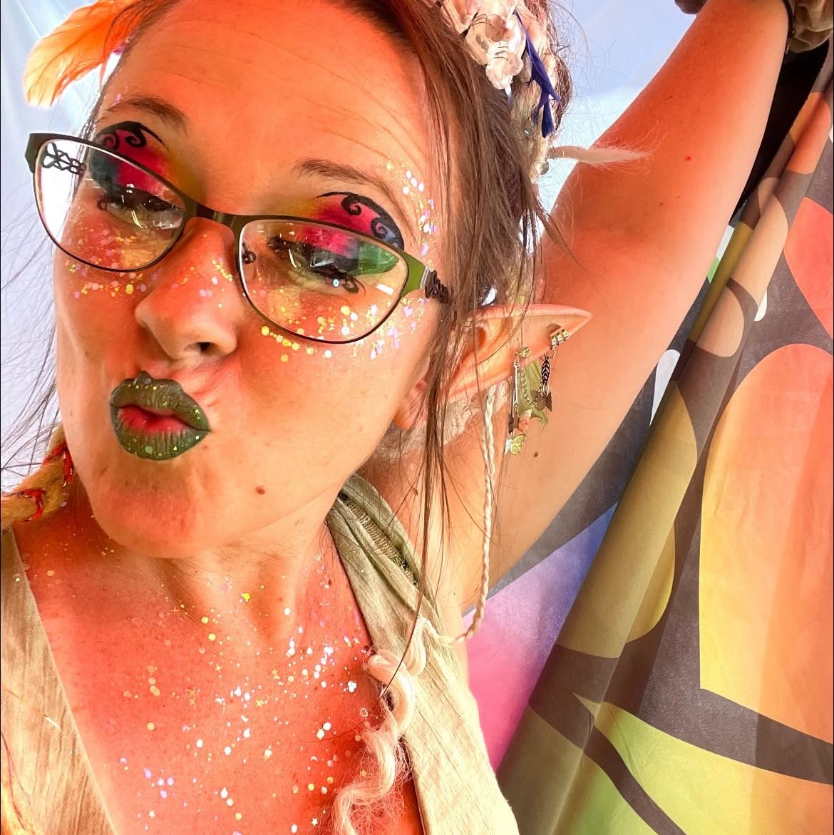 Fairy glitter makeup with olive lips and elf ears in warm light