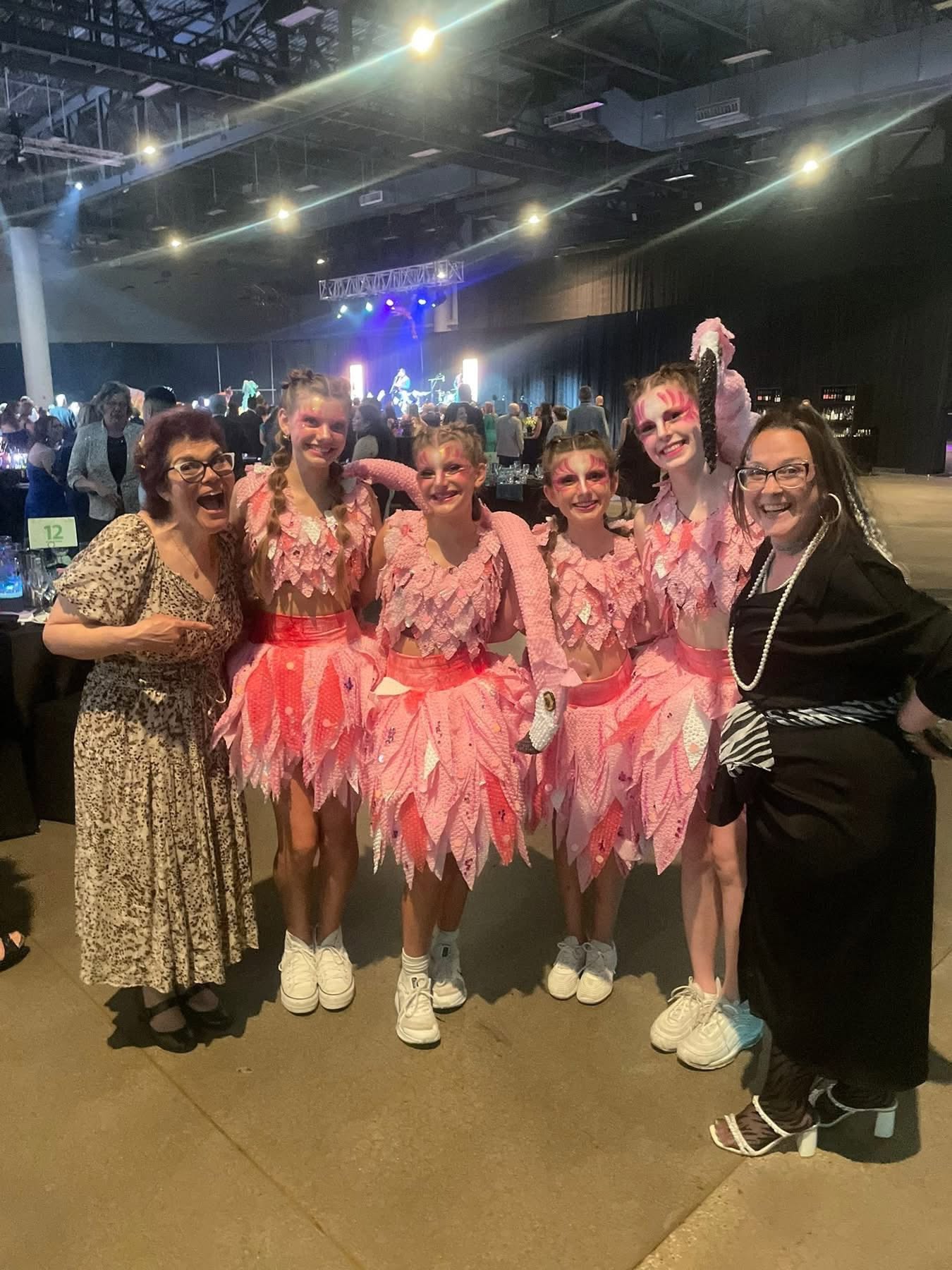 Tiah with a troupe of pink flamingo performers in matching face paint